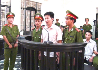 Mr Nguyen Hoang Quoc Hung inside the Vietnamese court, surrounded by the police.